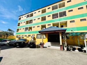 a large building with cars parked in a parking lot at เพิ่มพูนแมนชั่น พิษณุโลก Phoempun Mansion in Sathani Phitsanulok