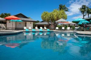 a large swimming pool with chairs and umbrellas at ❤PiH❤ Aloha Palms~ Fully Detached Home Beach Gear Bikes in Waikoloa