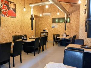 a dining room with tables and chairs in a restaurant at 別館JOUNi in Niijimamura