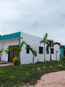 a white building with palm trees in front of it at Doña Dinde Vacacional in Punta Cana