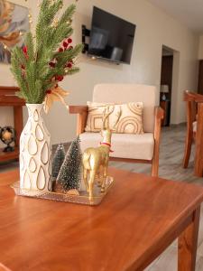 a table with a figurine of a deer and christmas trees at Doña Dinde Vacacional in Punta Cana