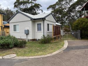 a white house with a fence in front of it at Moruya Heads Constable Street in Moruya Heads