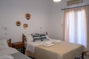 a bedroom with two beds with towels on them at Porto Analipsi in Maltezana