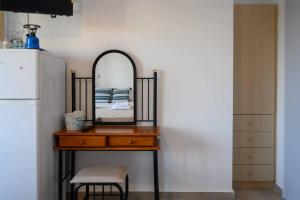 a dresser with a mirror on top of it next to a refrigerator at Porto Analipsi in Maltezana