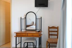 a dressing table with a mirror and a chair at Porto Analipsi in Maltezana