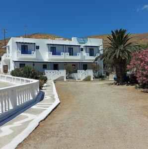 a white house with a palm tree in front of it at Porto Analipsi in Maltezana