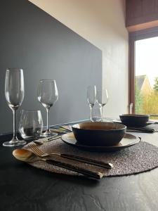 a table with plates and wine glasses on it at Ô Chalet Normand in Colomby