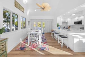 a kitchen with white counters and a table and chairs at Amarelo Sol in Captiva