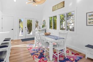 a white dining room with a table and chairs at Amarelo Sol in Captiva
