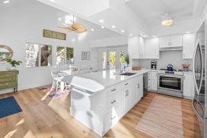 a kitchen with white cabinets and a large island at Amarelo Sol in Captiva +31 photos