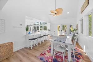 a white kitchen with white chairs and a table at Amarelo Sol in Captiva
