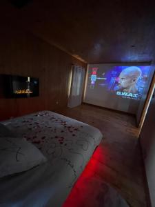 a bedroom with a bed and a large screen at Ô Chalet Normand in Colomby +1 photo