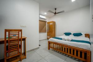 a bedroom with a bed and a desk in it at FORA Inn in Cochin +18 photos