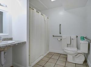 a white bathroom with a toilet and a sink at Classic Inn in Saco +9 photos