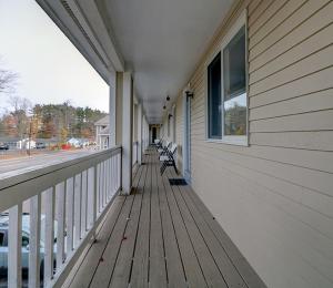 a porch of a building with benches on it at Classic Inn in Saco