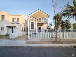 a white fence in front of a white house at Phan Thiết Nova World Malibu 2 Villa in Phan Thiet