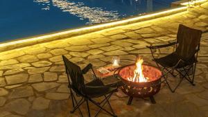 a fire pit with chairs and a table next to a pool at Gapyeong Orion PoolVilla pension in Gapyeong