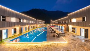 a hotel with a swimming pool in front of a building at Gapyeong Orion PoolVilla pension in Gapyeong