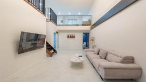a living room with a couch and a tv at Gapyeong Orion PoolVilla pension in Gapyeong