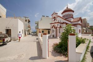 a person walking down a street next to a building at Kissamia Rooms - Next to Night Clubs in Kissamos