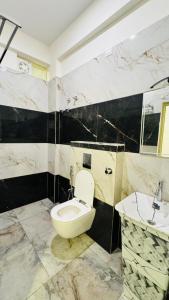 a bathroom with a toilet and a sink at SKB Suites in Mysore