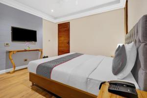a bedroom with a bed with a tv on the wall at Hotel IVY in New Delhi