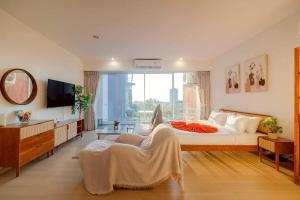 a bedroom with a bed and a chair and a tv at Seaview Residence Karon beach in Karon Beach