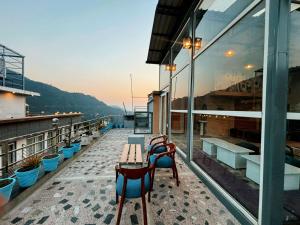 a balcony with benches and tables on a building at Trippme Rishikesh - Boutique Hostel, Tapovan in Rishīkesh