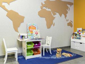 a room with a table and chairs and a map on the wall at Aparthotel Adagio Access Paris Asnières in Asnières-sur-Seine