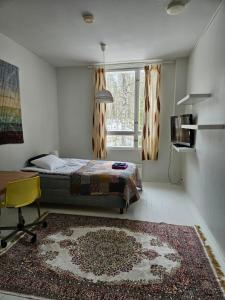 a bedroom with a bed and a window and a rug at B&B Aittoranta in Puolanka