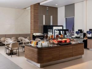 a restaurant with a buffet with food on it at ibis Bangkok Siam in Bangkok