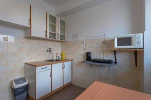 a small kitchen with a sink and a microwave at Hostel Turist in Zvolen