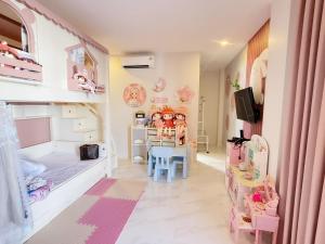a childs room with pink and blue furniture and a tv at Pool villa Cream Darin in Ban Hua Phrong