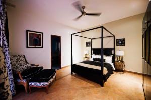 1 dormitorio con cama con dosel y silla en La Isabela Suites, en Panamá