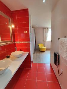 a bathroom with two sinks and a red wall at Gîte d'olympe in Graffigny-Chemin
