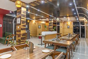 a restaurant with wooden tables and chairs at Hotel Mountain Nest in Nārkanda
