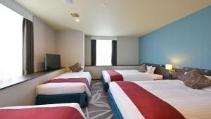 a hotel room with three beds and a tv at QUINTESSA HOTEL The Collection Osaka Bay in Osaka