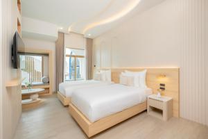 a bedroom with a large white bed and a tv at De Lunar Kohlarn in Ko Larn +58 photos