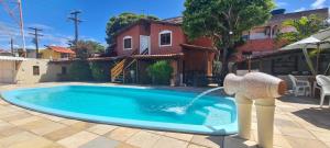 a pool with a water fountain in a yard at Chalé Beija Flor in Praia do Frances