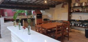 a kitchen and dining room with a table and chairs at Chalé Beija Flor in Praia do Frances
