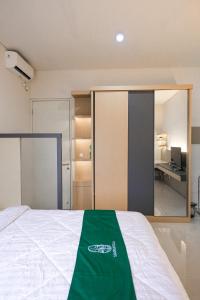 a bedroom with a bed with a green blanket on it at Sampai Villa Vasana in Yogyakarta +28 photos
