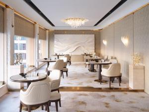 a restaurant with tables and chairs and a painting on the wall at Mandarin Oriental, Bangkok in Bangkok