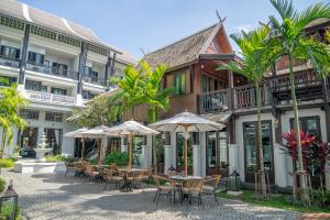 a courtyard with tables and chairs in front of a building at Buri Sriping Riverside Resort & Spa in Chiang Mai