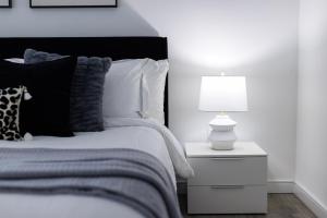 a bedroom with a bed with a lamp on a night stand at Stylish NYC Haven Steps to Broadway & Dining in New York +16 photos