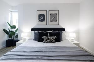 a bedroom with a large bed with three pictures on the wall at Stylish NYC Haven Steps to Broadway & Dining in New York