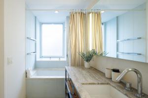 a bathroom with a tub and a sink and a bath tub at Stylish NYC Haven Steps to Broadway & Dining in New York
