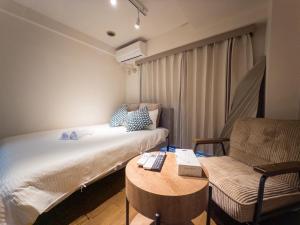 a small room with a bed and a chair at Ichigaya Stay & Wi-Fi 1 in Tokyo