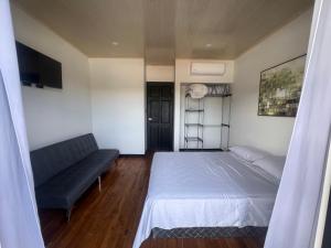 a bedroom with a bed and a couch at Live bambu in Caimital