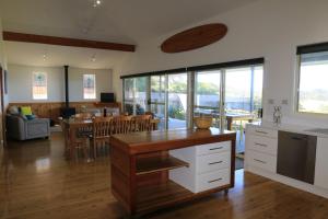 una cucina e una sala da pranzo con tavolo e sedie di Bunkys By The Sea Holiday House a Berrara