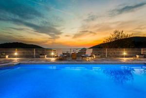 una piscina con puesta de sol en el fondo en Villa Idealia, en Panormos Skopelos
